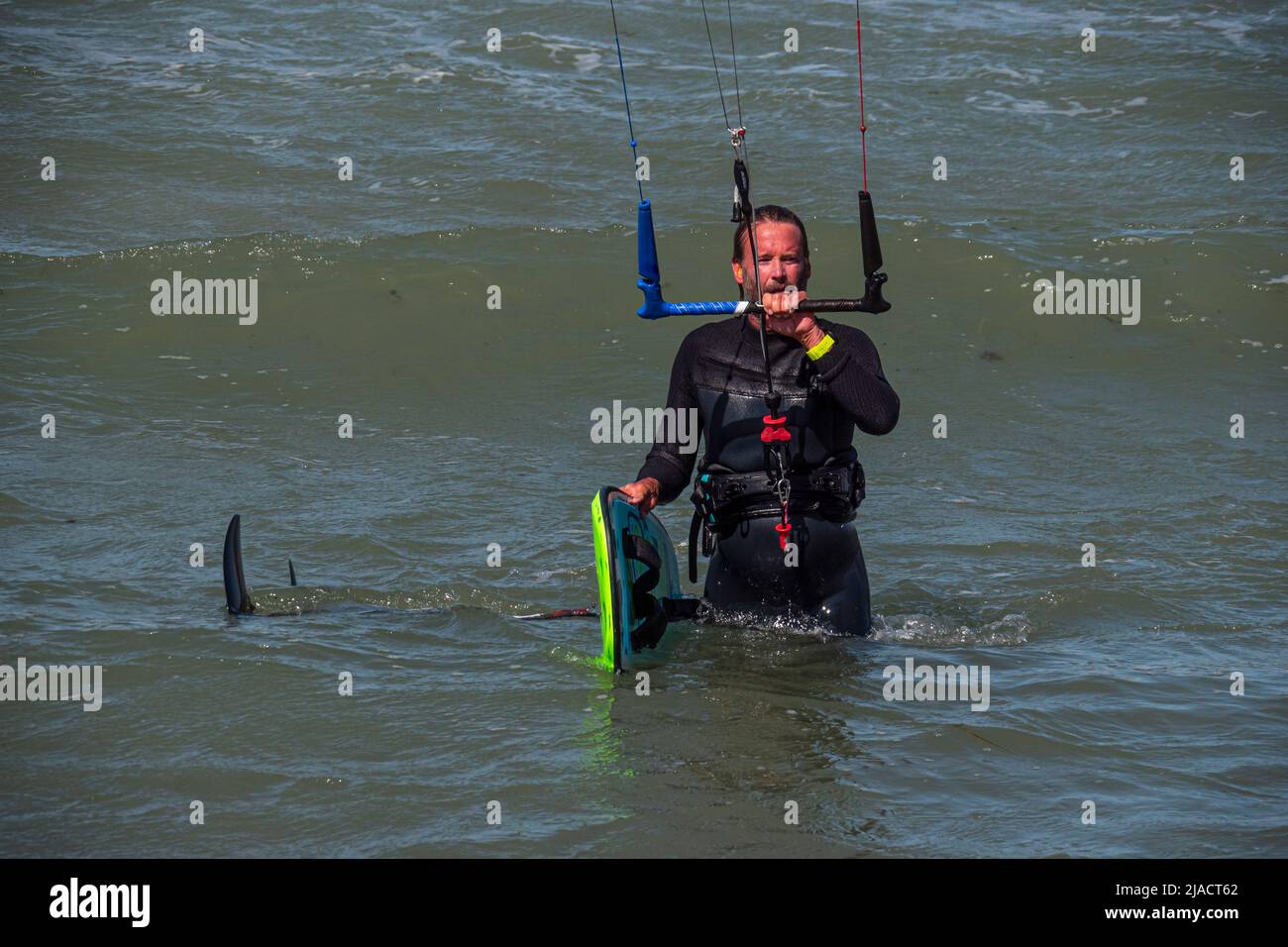 Kite Surfer esce dal mare con foilboard e trapezio Foto Stock