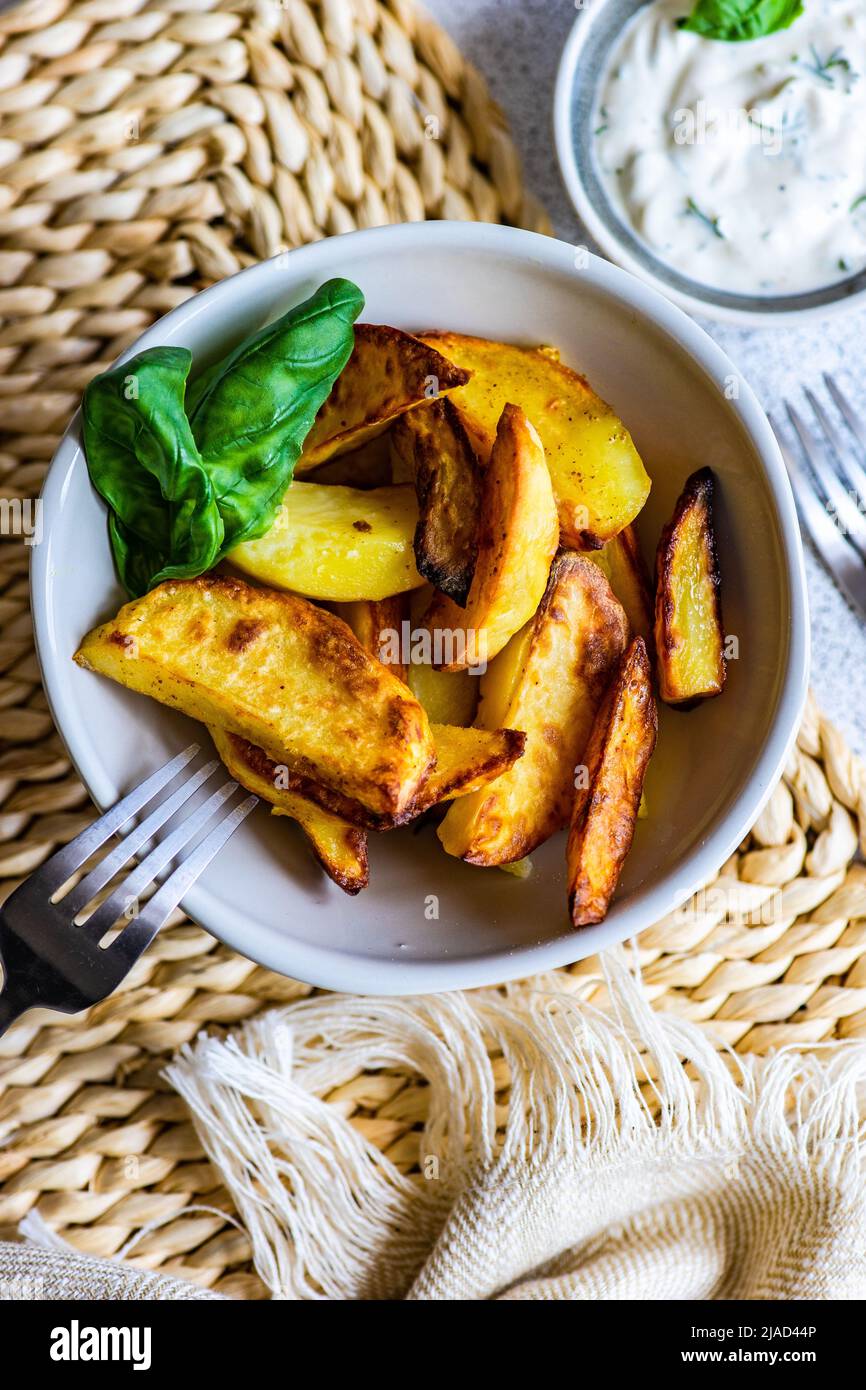 Vista dall'alto di una ciotola di patate arrosto con salsa panna acida Foto Stock