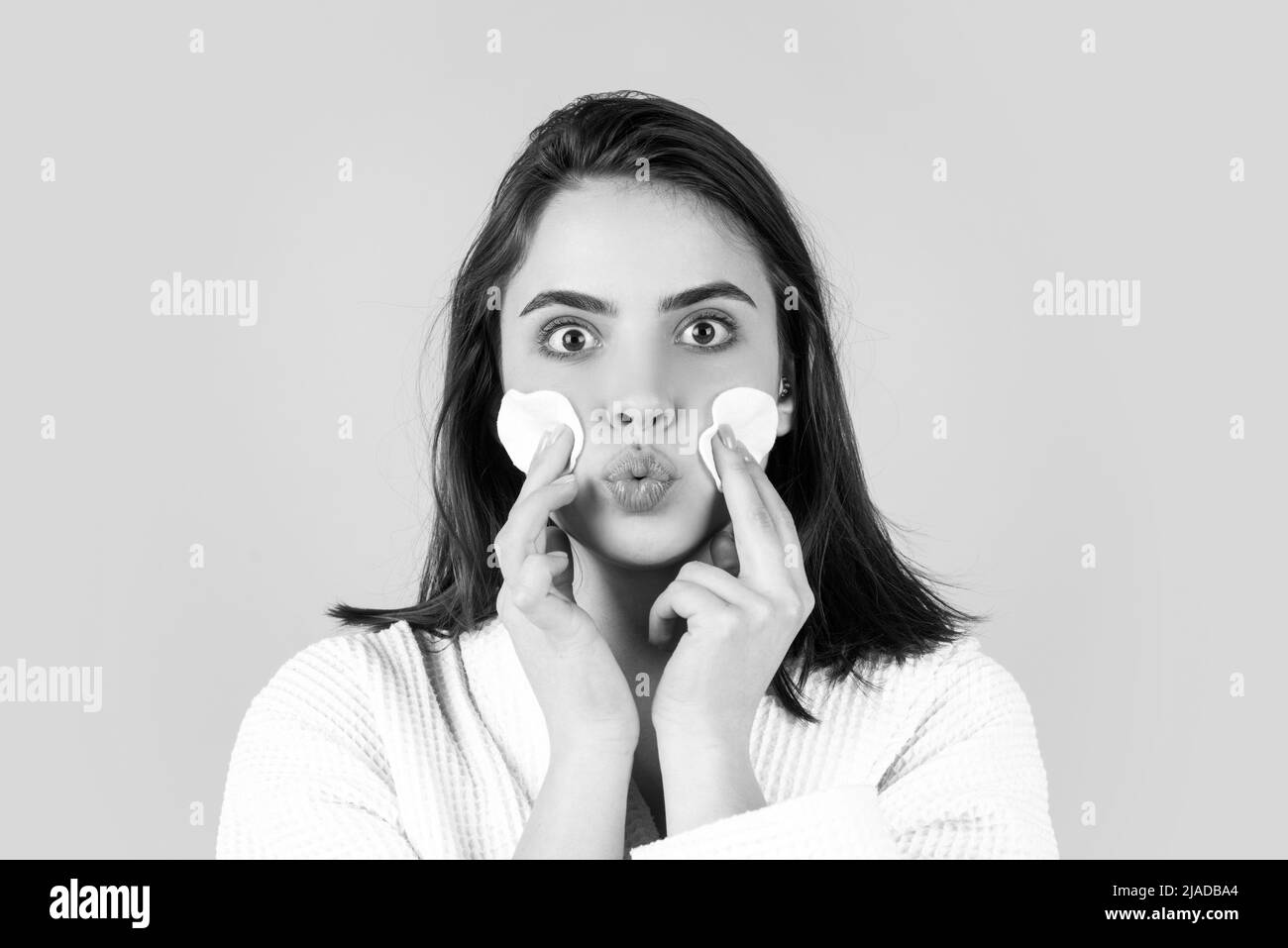 Bella ragazza giovane con procedure giornaliere mattina per la cura della pelle, pulizia della pelle del viso con lozione tonica naturale utilizzando cotone disco spugna tampone. Bella ragazza Foto Stock