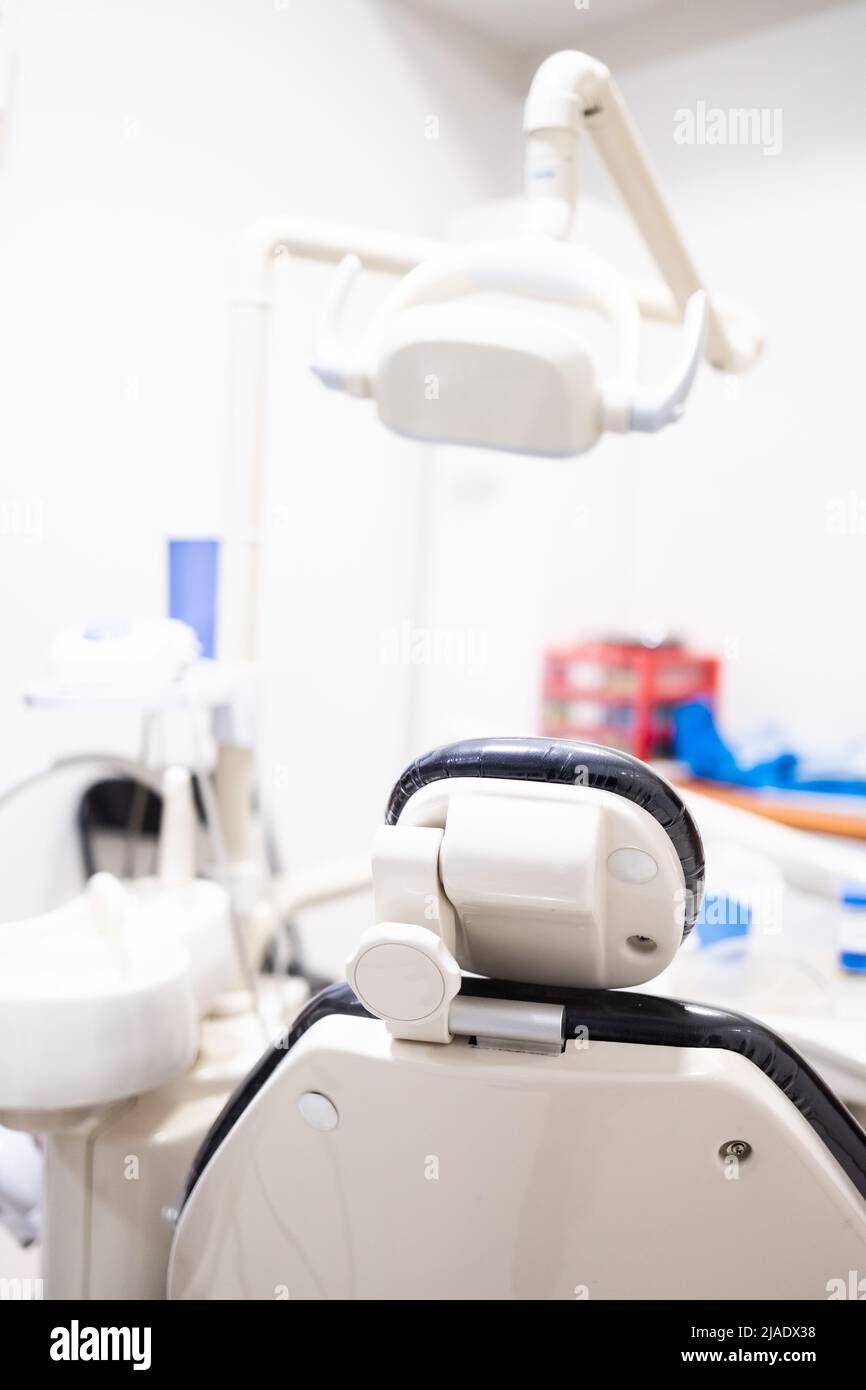 Sedia dentista visto da dietro. Odontoiatria, medicina, attrezzatura medica e concetto di stomatologia. Verticale Foto Stock