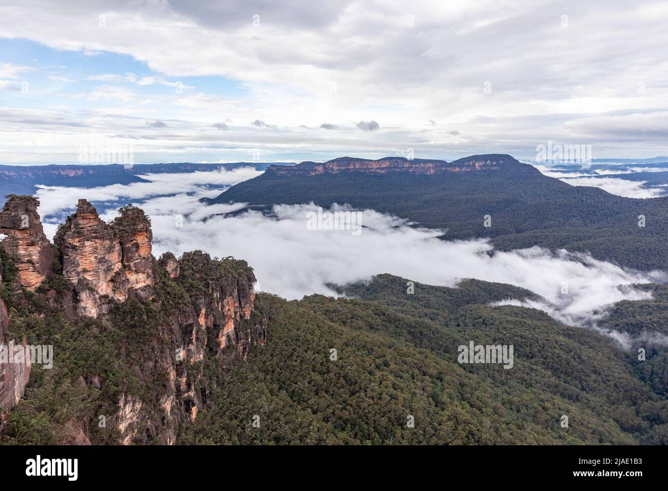 Tre Sorelle nell'area del Patrimonio Mondiale delle Blue Mountains e Mount Solitary all'interno della Jamison Valley con inversione della nuvola, NSW, Australia Foto Stock