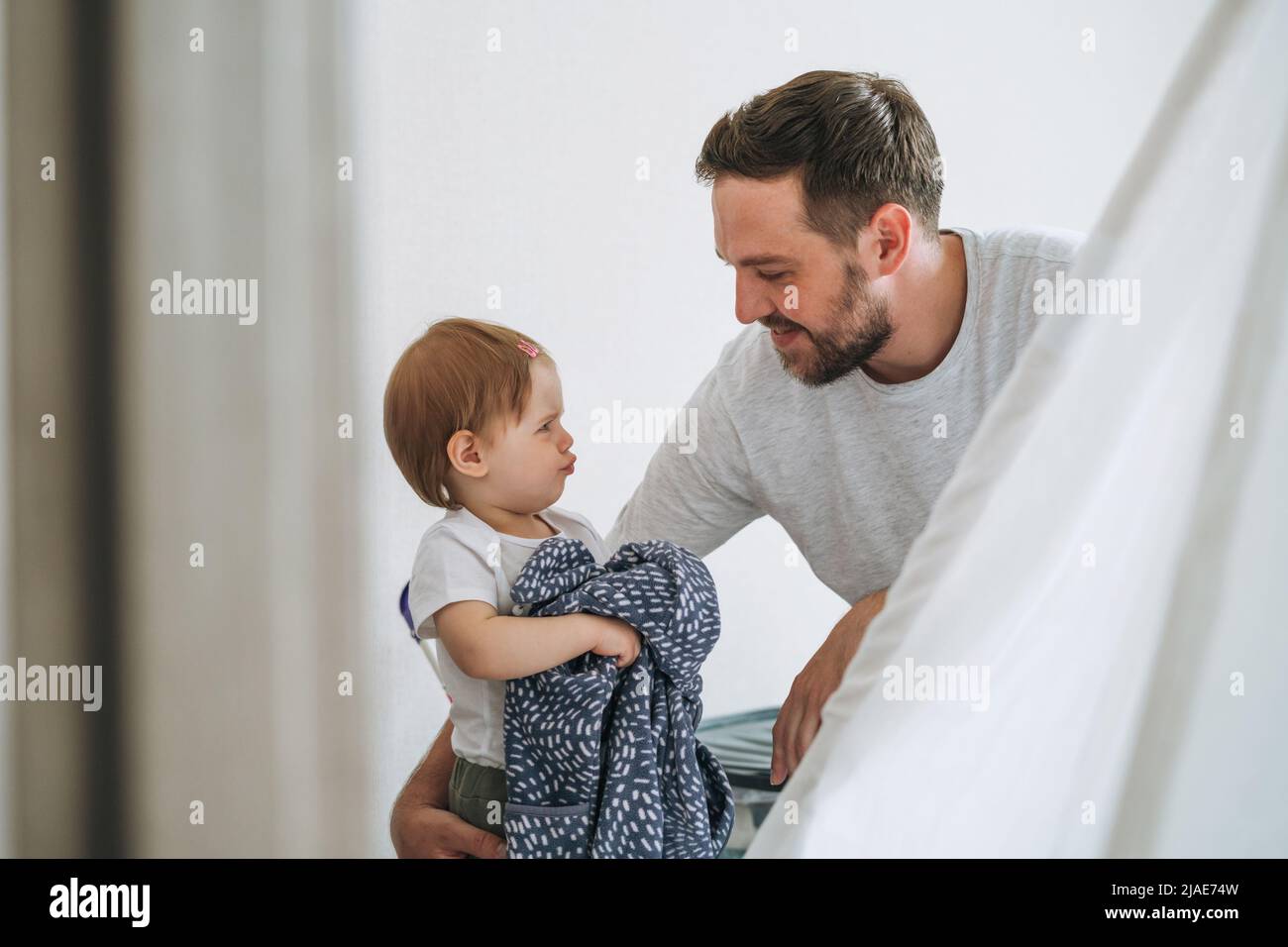 Padre giovane uomo e piangendo sconvolto bambina piccola figlia nella stanza dei bambini a casa Foto Stock