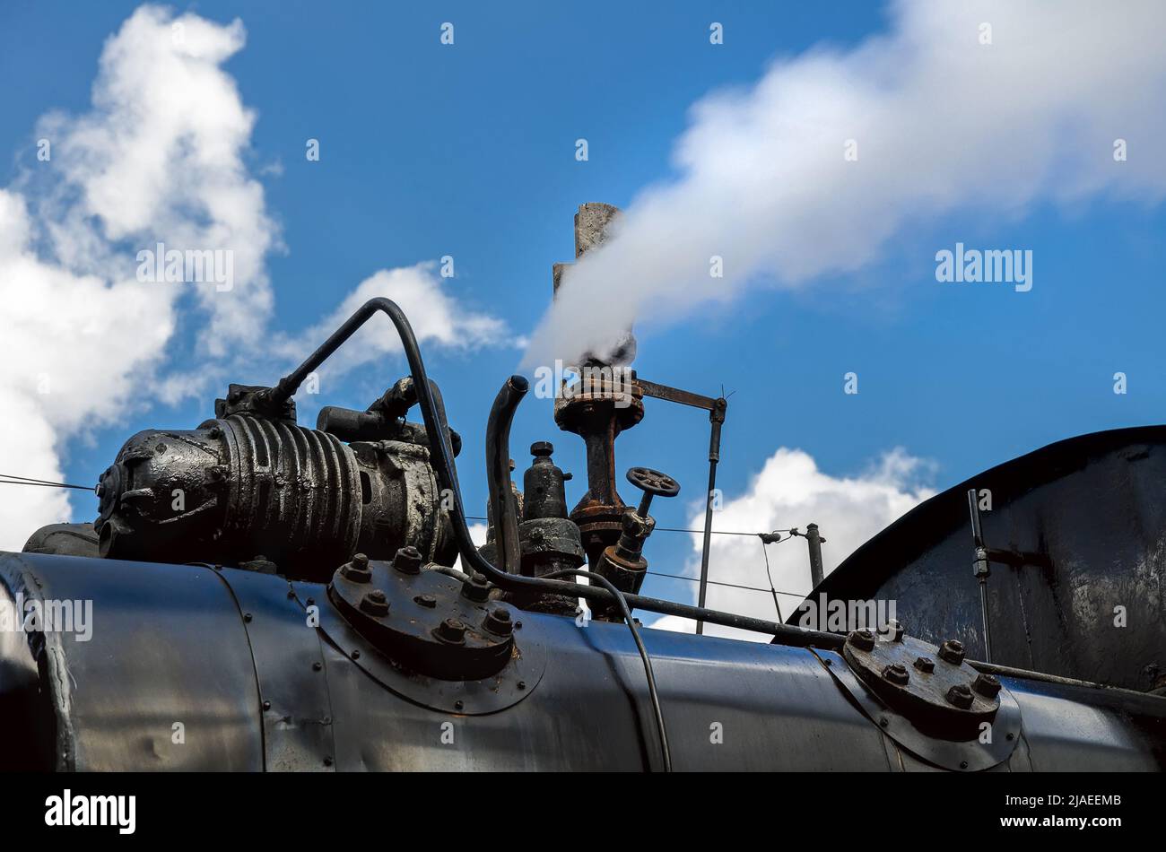 Il fischio della vecchia locomotiva a vapore produce vapore bianco. Foto Stock