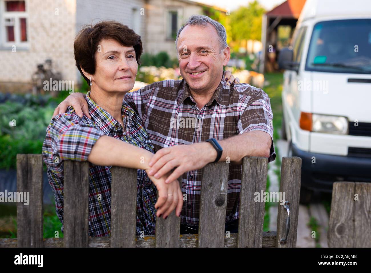 coppia anziana vicino alla recinzione che abbraccia il villaggio Foto Stock