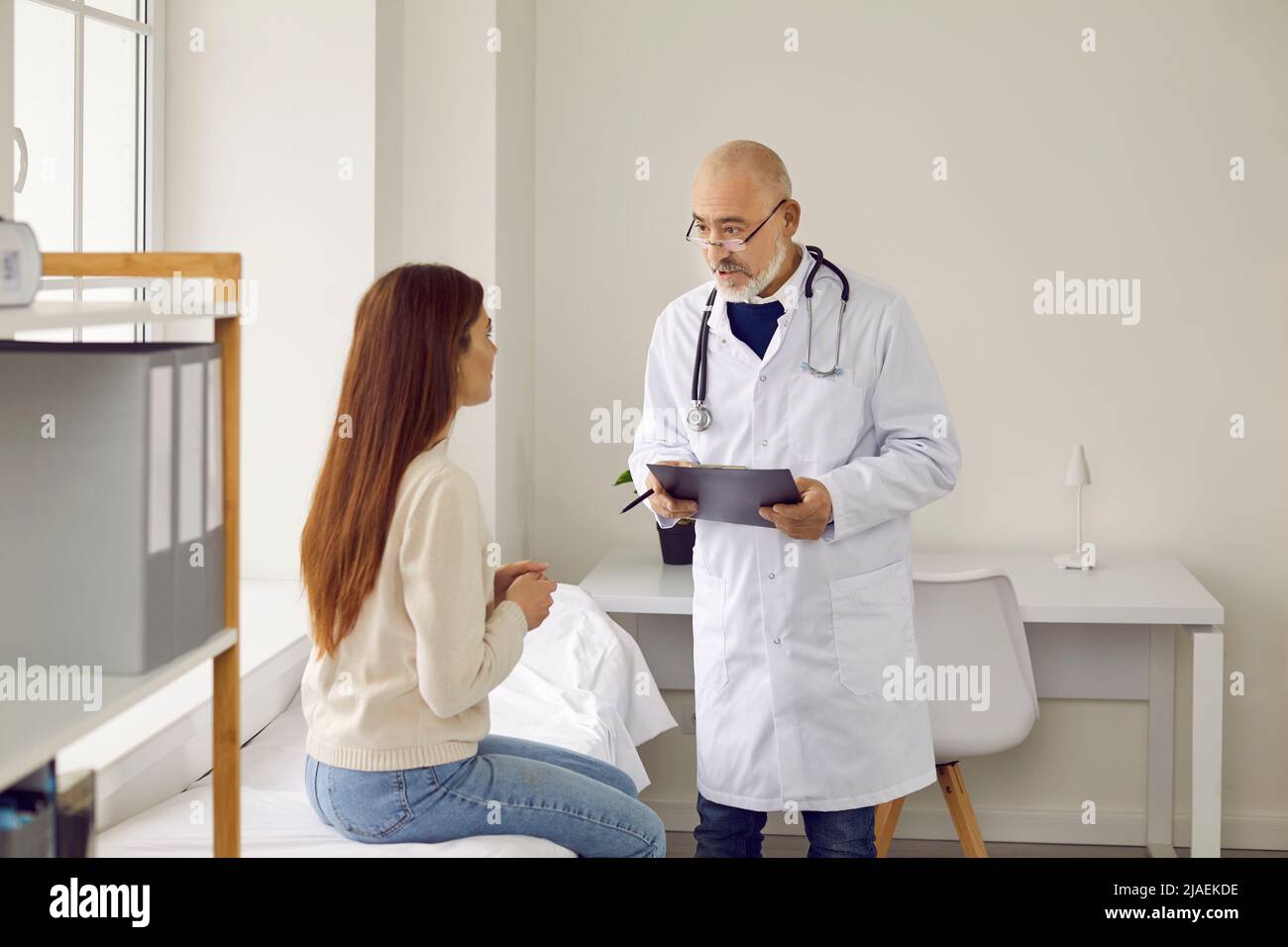 Il medico di sesso maschile consulta la paziente in ospedale Foto Stock