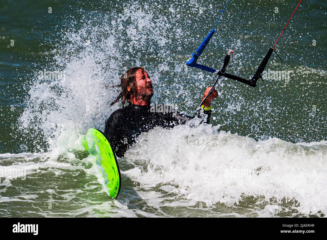 Il kitesurfer maschio ottiene colpito da un'onda dopo la caduta, primo piano Foto Stock