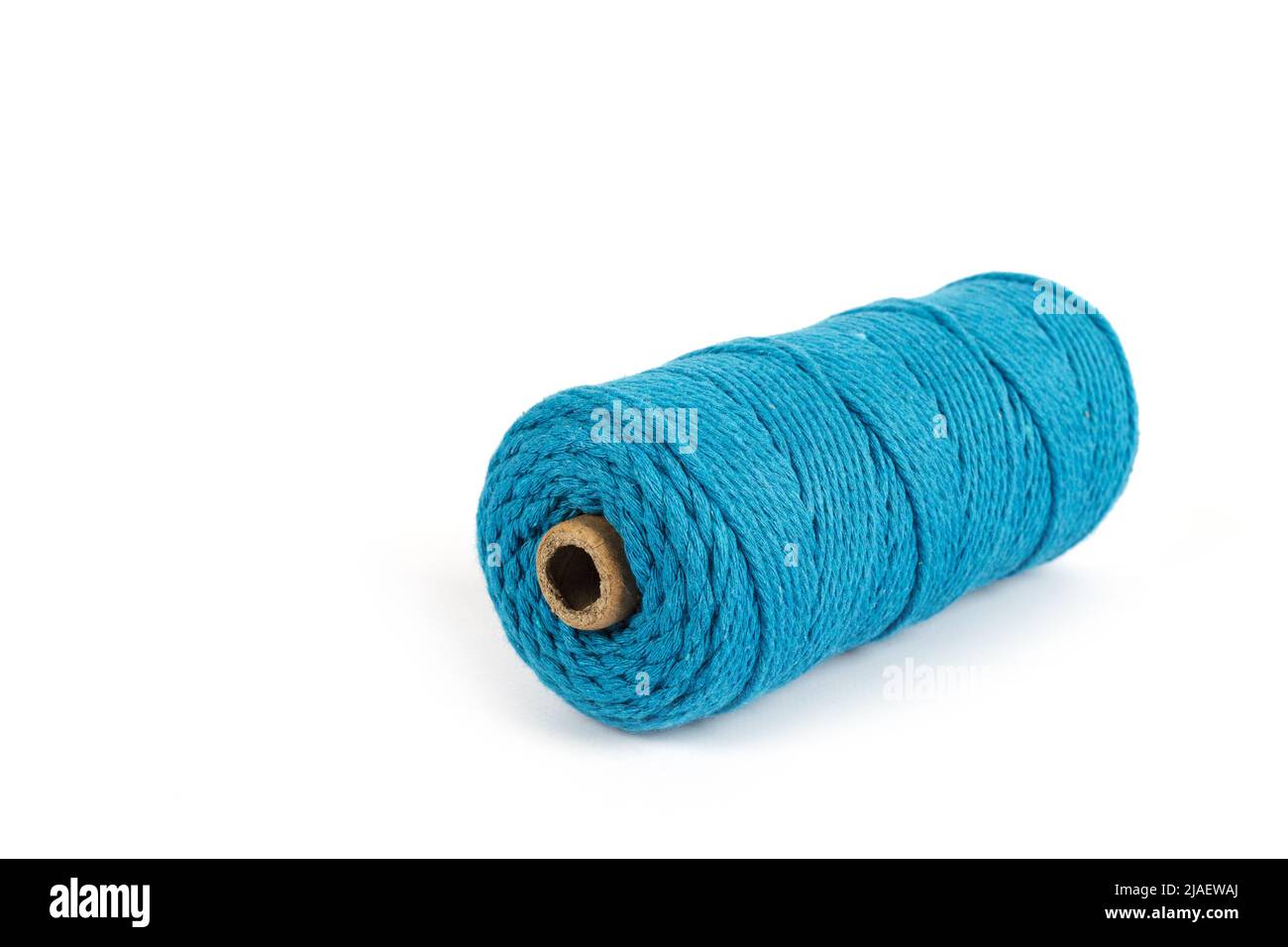 Matassa di colore blu a filo singolo corda di cotone per macrama su bianco. Da utilizzare per il fai-da-te. Primo piano bobina tessile Foto Stock