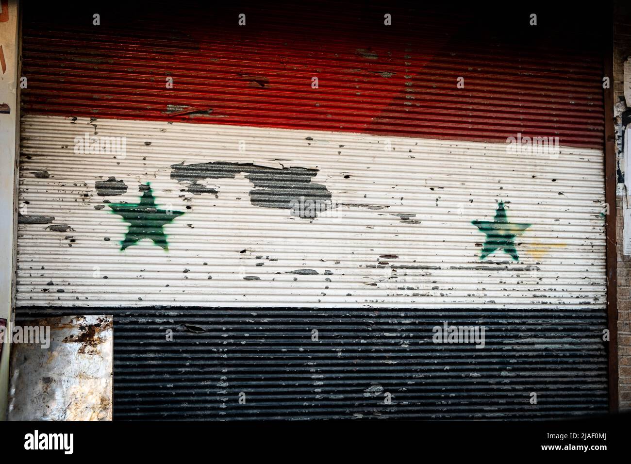 Damasco, Siria - Maggio 2022: Bandiera nazionale siriana dipinta su persiane chiuse Foto Stock