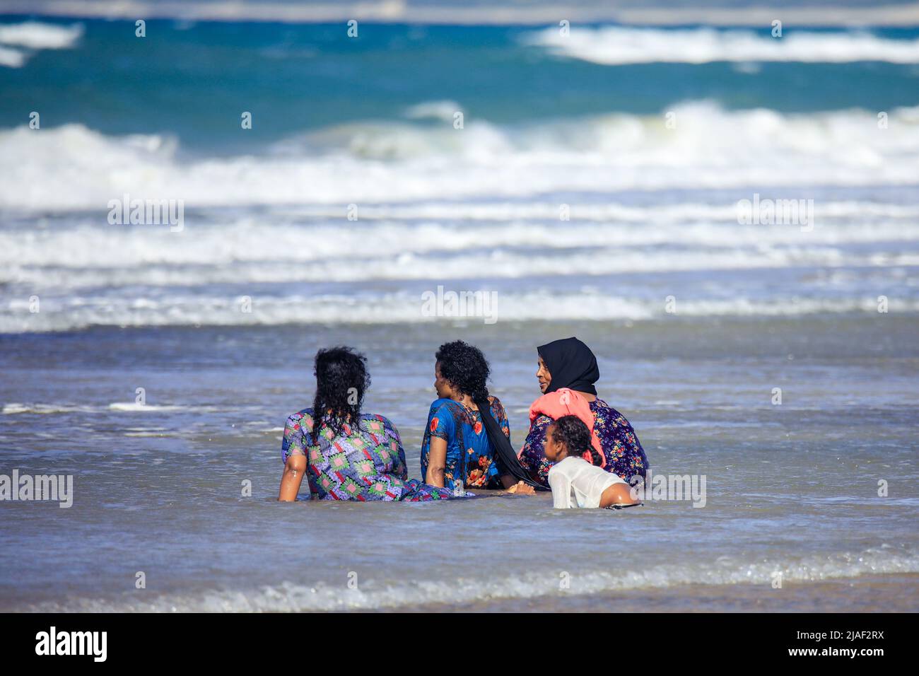 La gente del posto nuotare nelle acque calde il giorno del sole sulla costa berbera Foto Stock