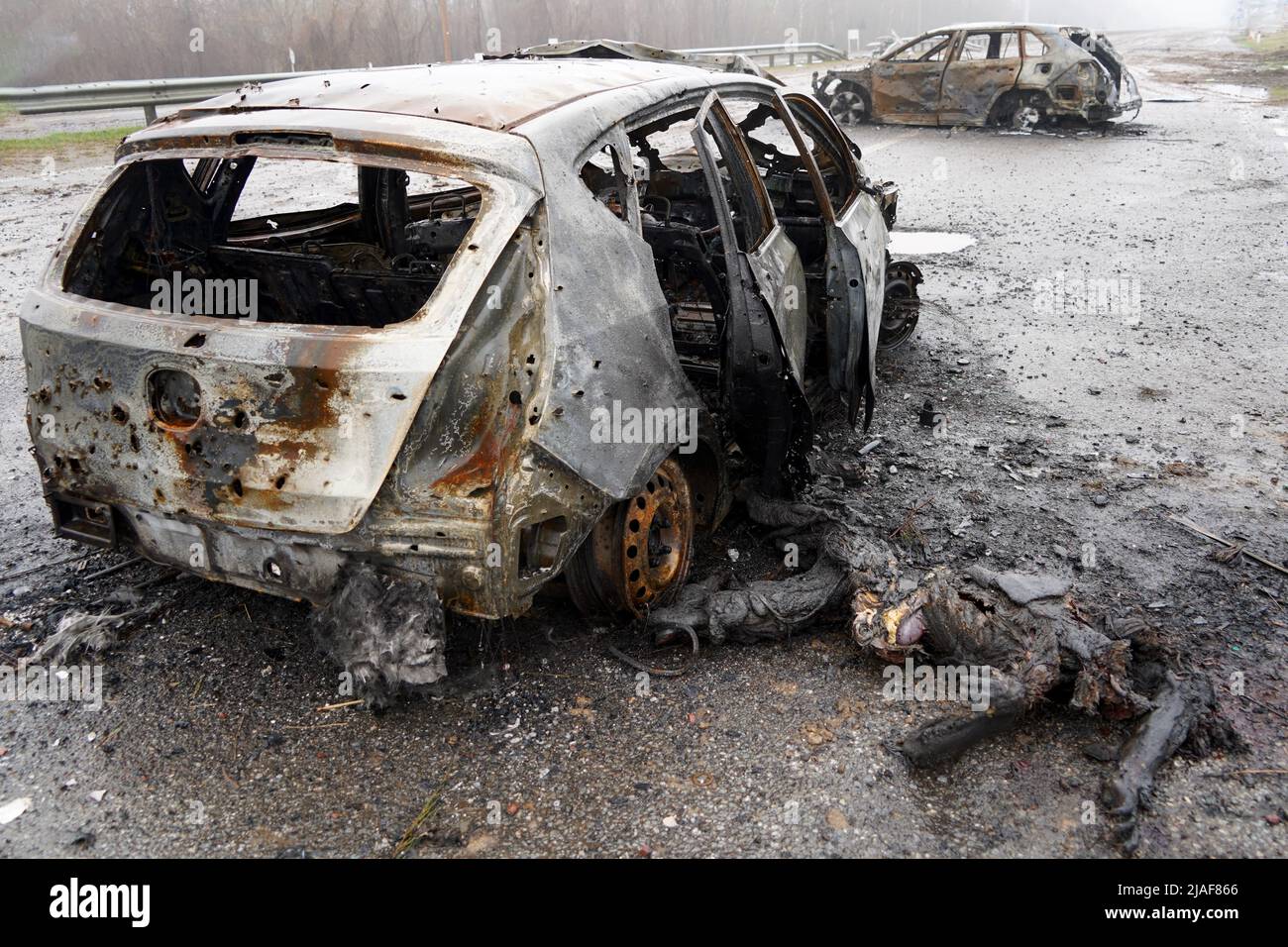 Auto bruciata durante la guerra in Ucraina. Edifici distrutti, strade. Tecnica di Ucraina civile Foto Stock