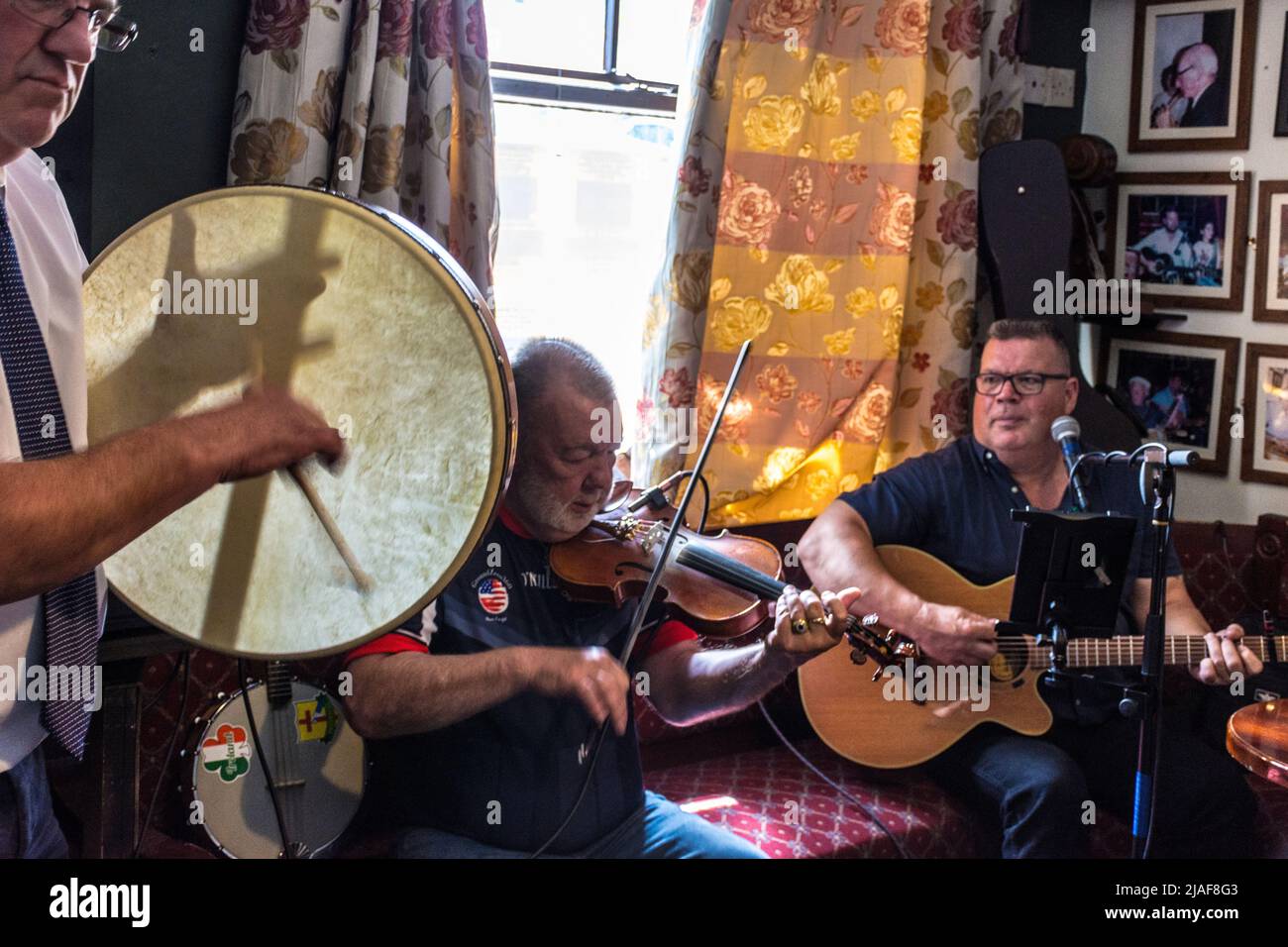 Musica tradizionale irlandese in un bar Donegal. Un uomo suona la percussione su un bodhran. Foto Stock