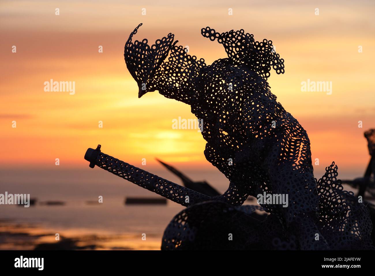 Figura scultorea a grandezza naturale nel giardino D-Day 75 di Arromanches-les-Bains, Francia al tramonto. L'installazione è stata creata per la prima volta da John Everiss for Foto Stock