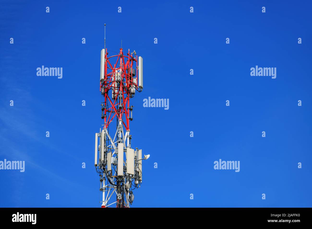 Traliccio di telecomunicazioni con ripetitori di segnale e antenne contro il cielo blu per tecnologia wireless e concetto di industria di radiodiffusione, spazio copia incl Foto Stock