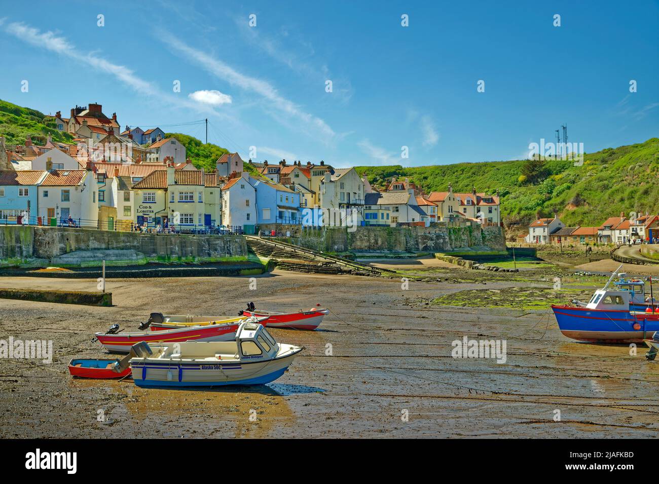 Porto e villaggio con il 'Cod & Lobster' Inn a Staithes, North Yorkshire, Inghilterra. Foto Stock