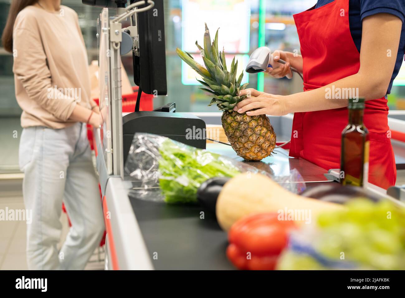 Giovane donna caucasica adulta con capelli lunghi e outfit casual acquistare alimenti in moderno supermercato Foto Stock
