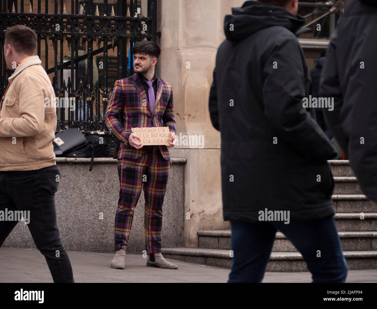 Cercatore di lavoro a London Liverpool Street, con cartello che richiede opportunità di lavoro da pendolari Foto Stock