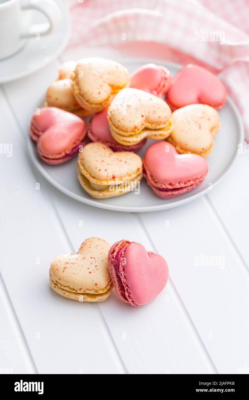 A forma di cuore Dolce macaron su un tavolo bianco. Foto Stock