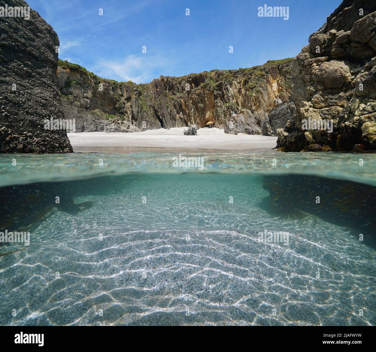 Riva del mare di spiaggia sabbiosa appartata tra le rocce, vista su e sotto la superficie dell'acqua, oceano Atlantico, Spagna, Galizia, Rias Baixas Foto Stock