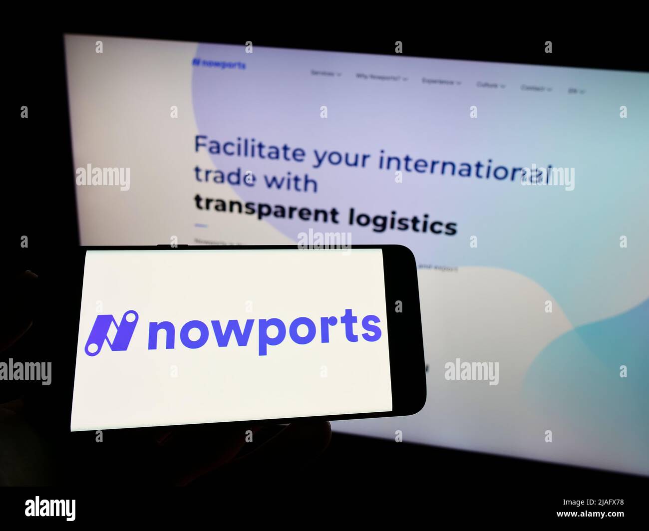 Persona che detiene il telefono cellulare con il logo della società di logistica Nowports Mexico SA de CV sullo schermo di fronte alla pagina web. Mettere a fuoco sul display del telefono. Foto Stock