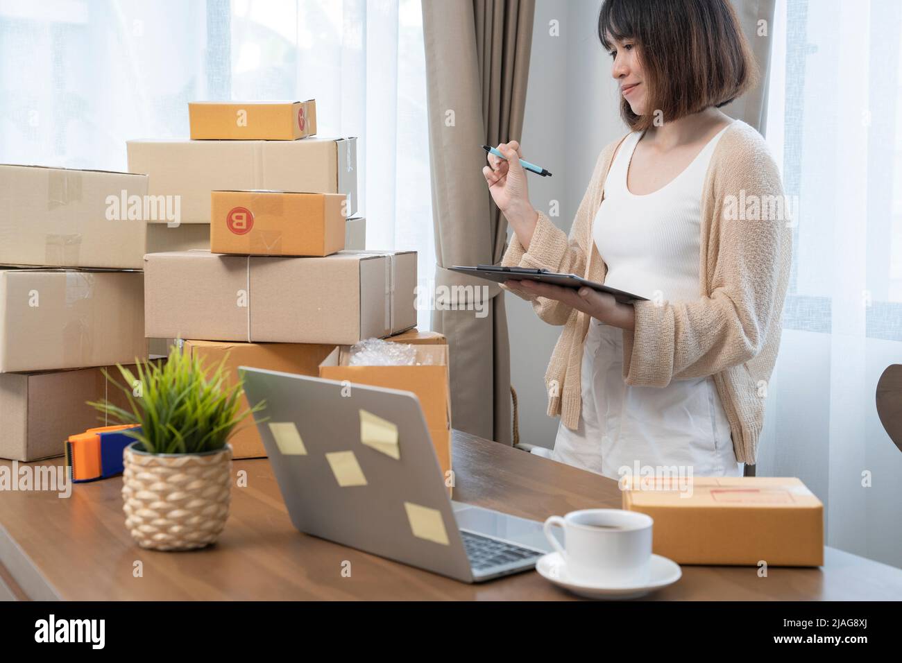 Le donne asiatiche che contano le scatole prima della spedizione ai clienti, il lavoro dalla sede, i proprietari di piccola impresa o gli imprenditori di piccola impresa appena che iniziano il worki Foto Stock