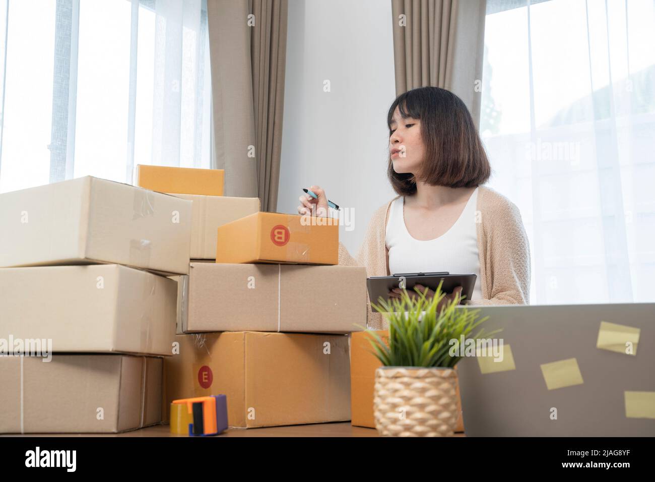 Le donne asiatiche che contano le scatole prima della spedizione ai clienti, il lavoro dalla sede, i proprietari di piccola impresa o gli imprenditori di piccola impresa appena che iniziano il worki Foto Stock