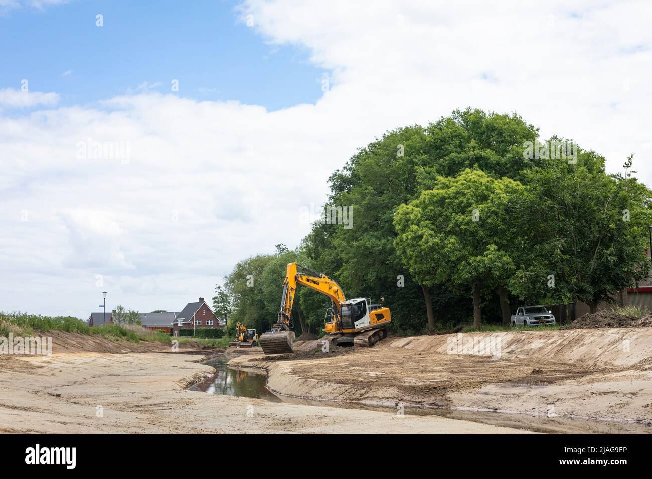Escavatori al lavoro ripristinare la razionalizzazione della rete in una zona residenziale, la gestione delle acque nei Paesi Bassi Foto Stock