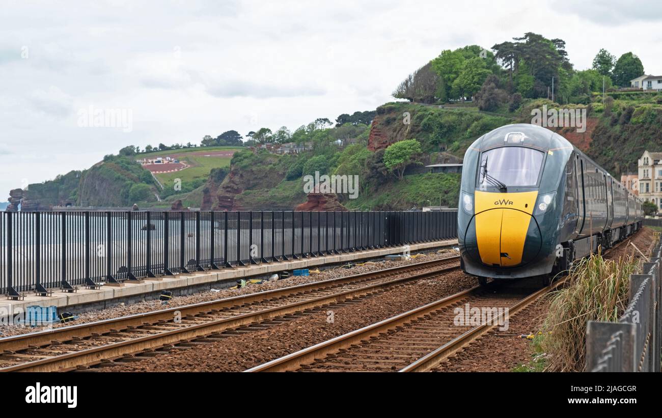 Dawlish, Inghilterra - 12 maggio 2022: Un treno passeggeri della Great Western Railway diretto a London Paddington in avvicinamento alla stazione di Dawlish sulla costa Foto Stock