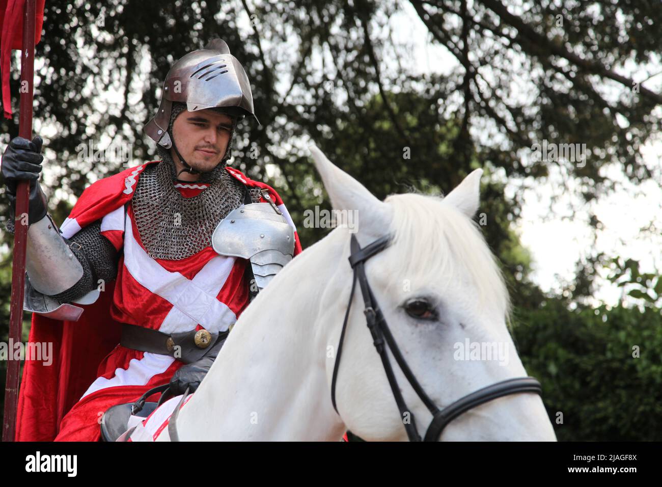 Cavaliere in armatura splendente su cavallo bianco torna al castello di Warwick, Warwickshire, Inghilterra, UK, 2022 Foto Stock