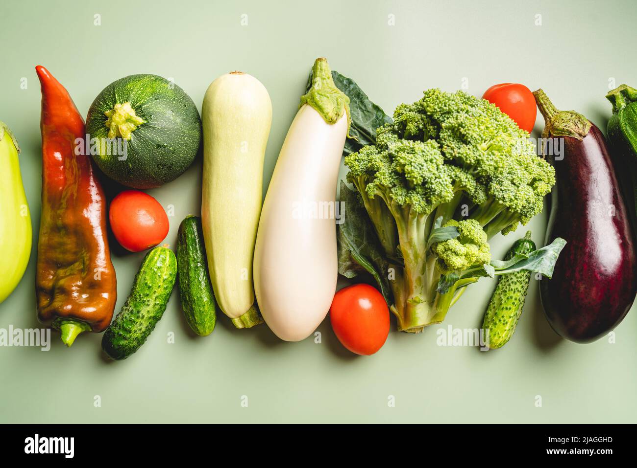 Verdure verdi biologiche eco-compatibili su sfondo verde. Disposizione piatta, vista dall'alto. Dieta sana e pulita e disintossicazione Foto Stock
