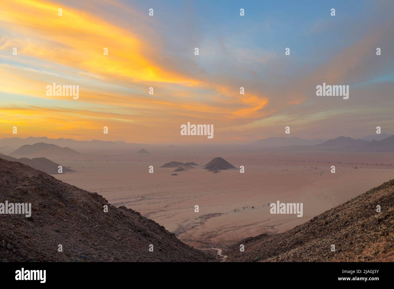 Il vento d'oro ha spazzato le nuvole al tramonto in Namibia Foto Stock