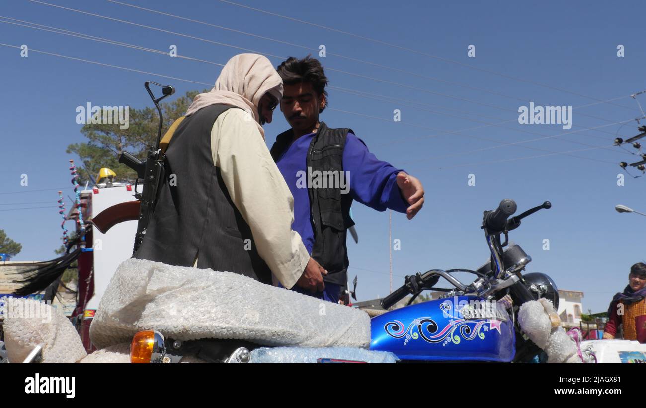 Herat. 30th maggio 2022. Un membro della forza di sicurezza afghana cerca un uomo in un checkpoint nella provincia di Herat, in Afghanistan, il 30 maggio 2022. La polizia ha scoperto 9 kg di eroina nella provincia occidentale di Herat in Afghanistan e ha portato due presunti trafficanti di droga in custodia, l'agenzia di notizie Bakhtar, gestita dallo stato, ha riferito Domenica. Credit: Mashal/Xinhua/Alamy Live News Foto Stock