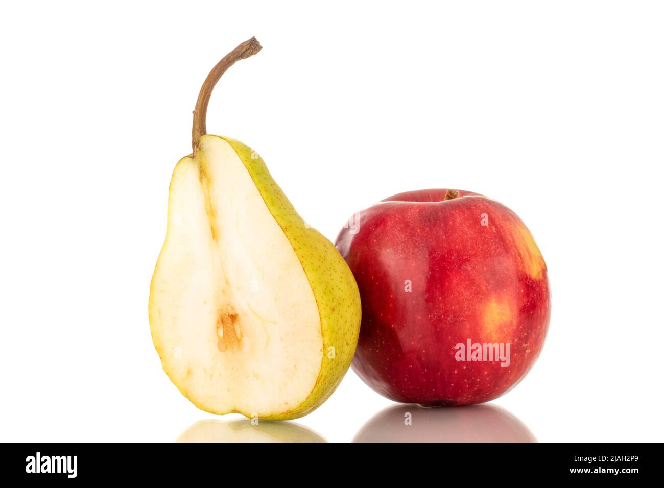 Metà di una pera gialla succosa e una mela rossa, primo piano, isolata su sfondo bianco. Foto Stock