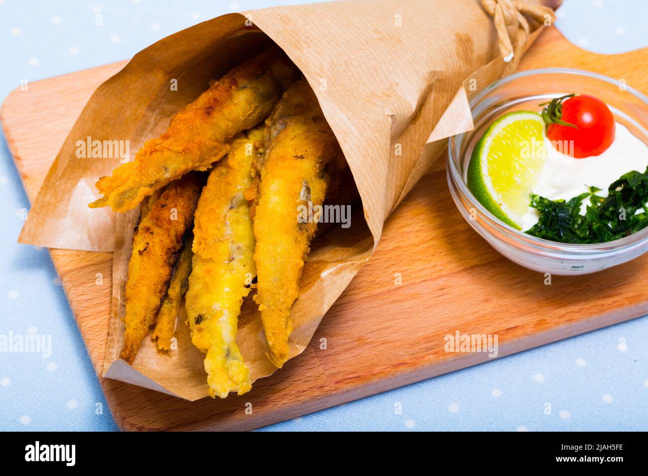 Acciughe fritte in padella con salsa cremosa al formaggio, verdure Foto Stock