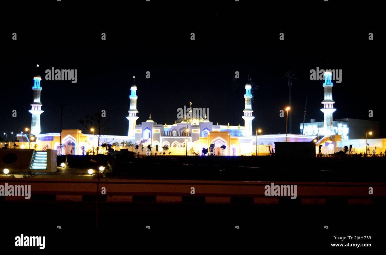 Scena notturna di una grande moschea al Cairo Egitto con cupole multiple e minareti pieni di luci colorate, musulmani eseguire le loro cinque preghiere del giorno Foto Stock
