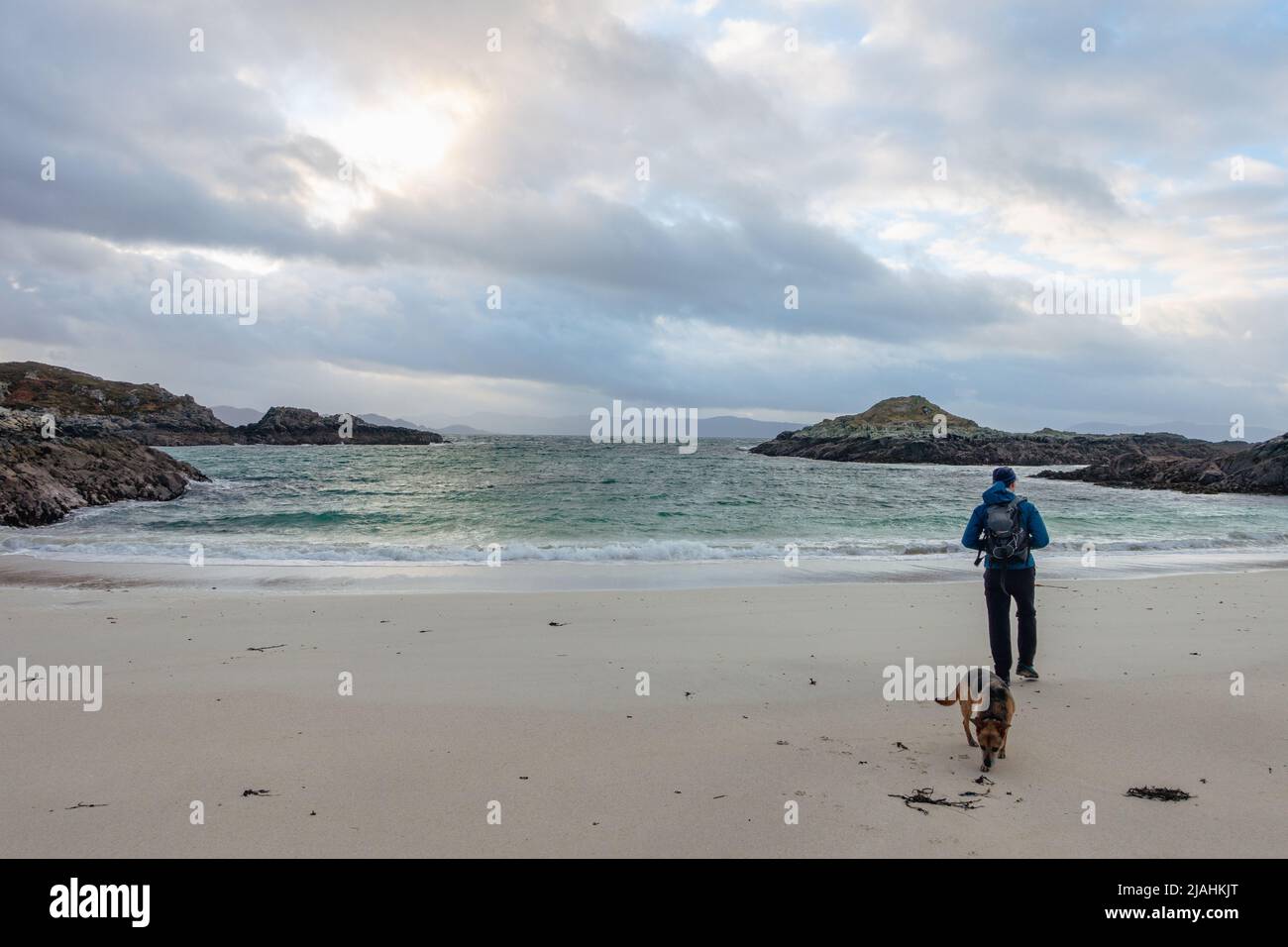 Scottish Seascape - Rhu Point Beach in inverno con persona che cammina il suo cane, Port Nam Murrach sulla penisola di Rhu vicino Arisaig, Morar, Scozia Foto Stock