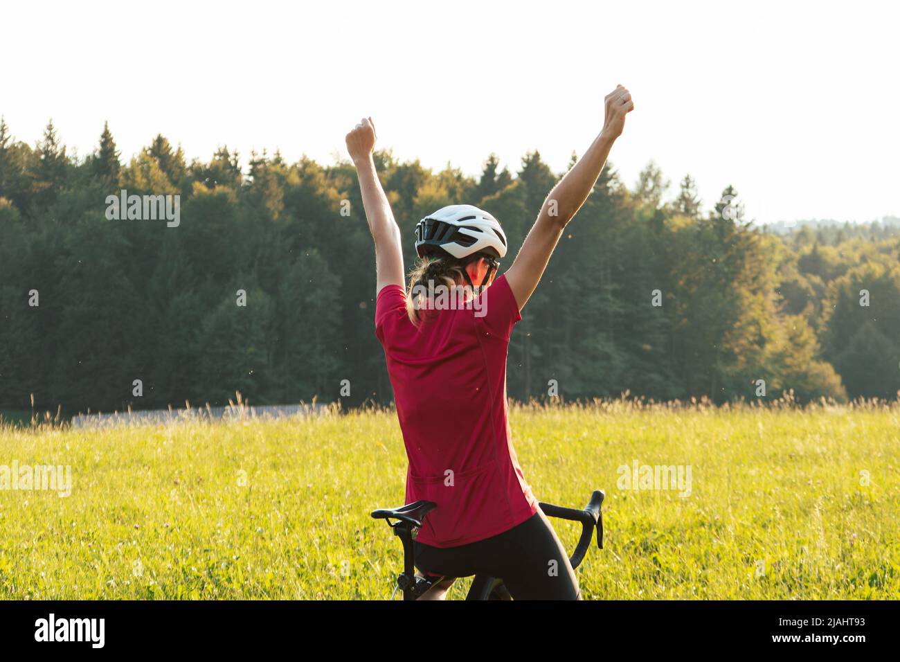 Giovane donna professionista bicyclist durante la corsa su strada, movimento continuo con massimo sforzo, vista ravvicinata. Foto Stock