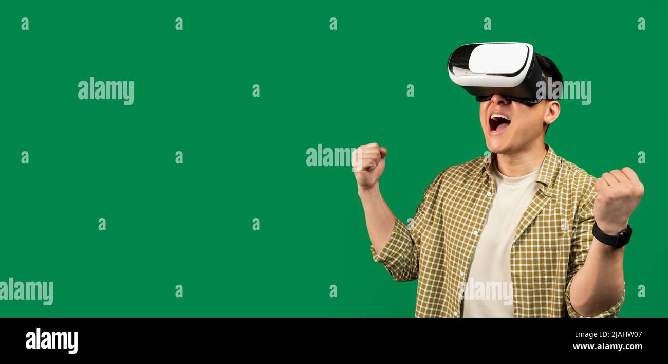 L'uomo maturo asiatico ha gioito in occhiali per visore VR che giocano ai cyber giochi e celebrano emozionalmente la vittoria, spazio libero Foto Stock