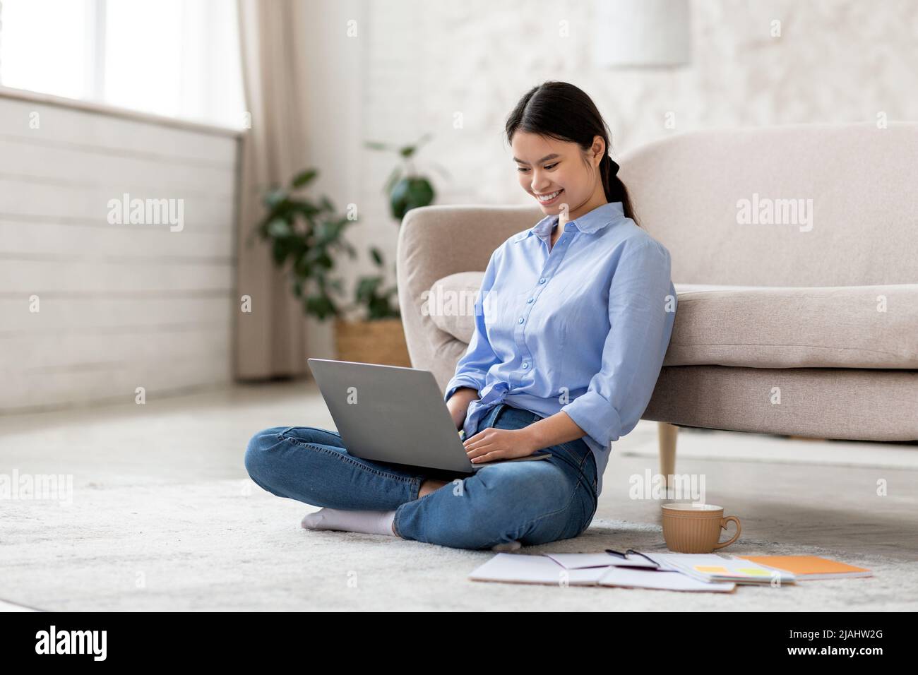 Allegra signora coreana che lavora al progetto a casa Foto Stock