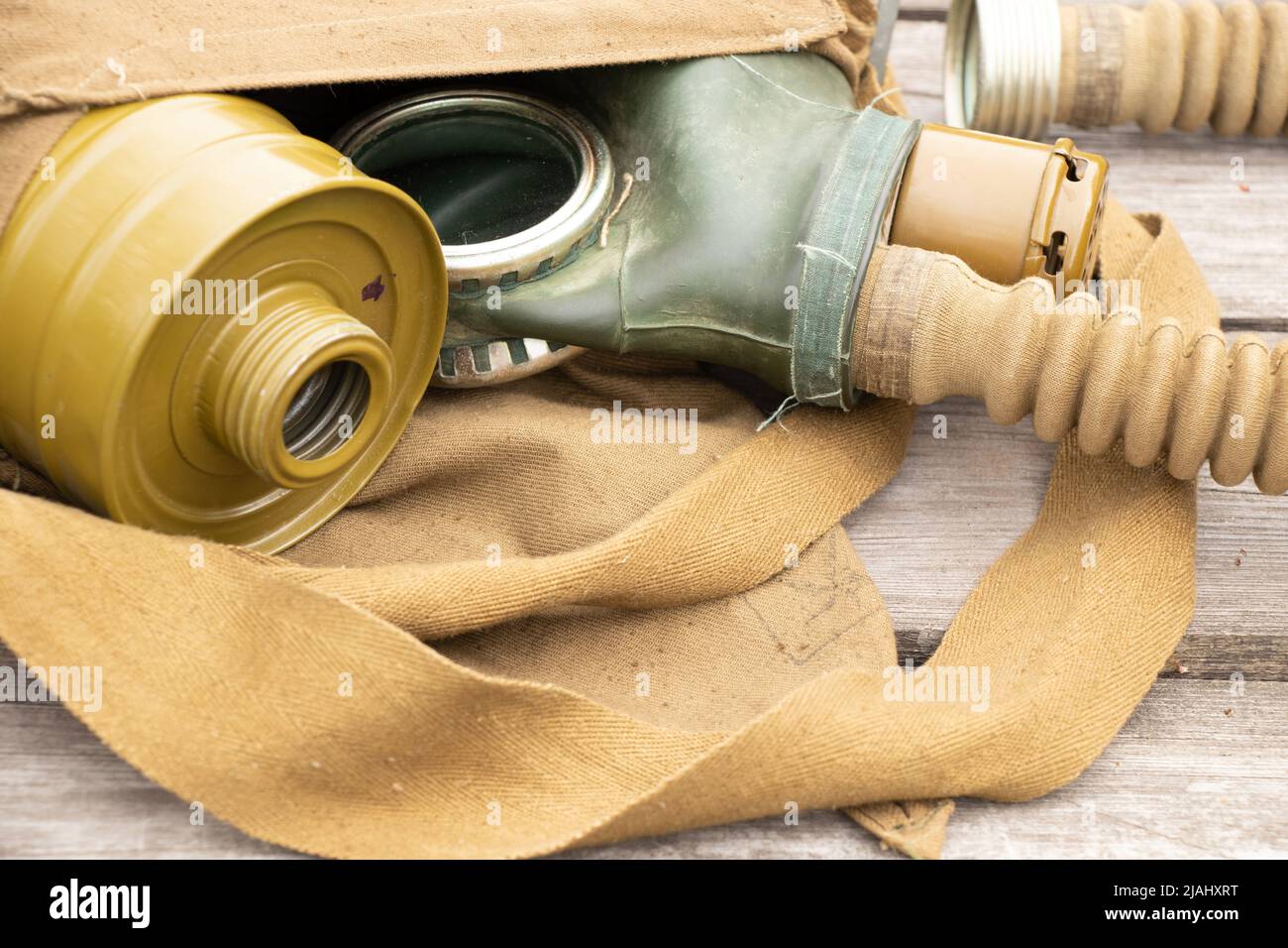 Vintage maschera di gas si trova su uno sfondo di legno, attacco di gas in Ucraina in guerra, maschera protettiva, ecologia, attacco chimico durante la guerra Foto Stock