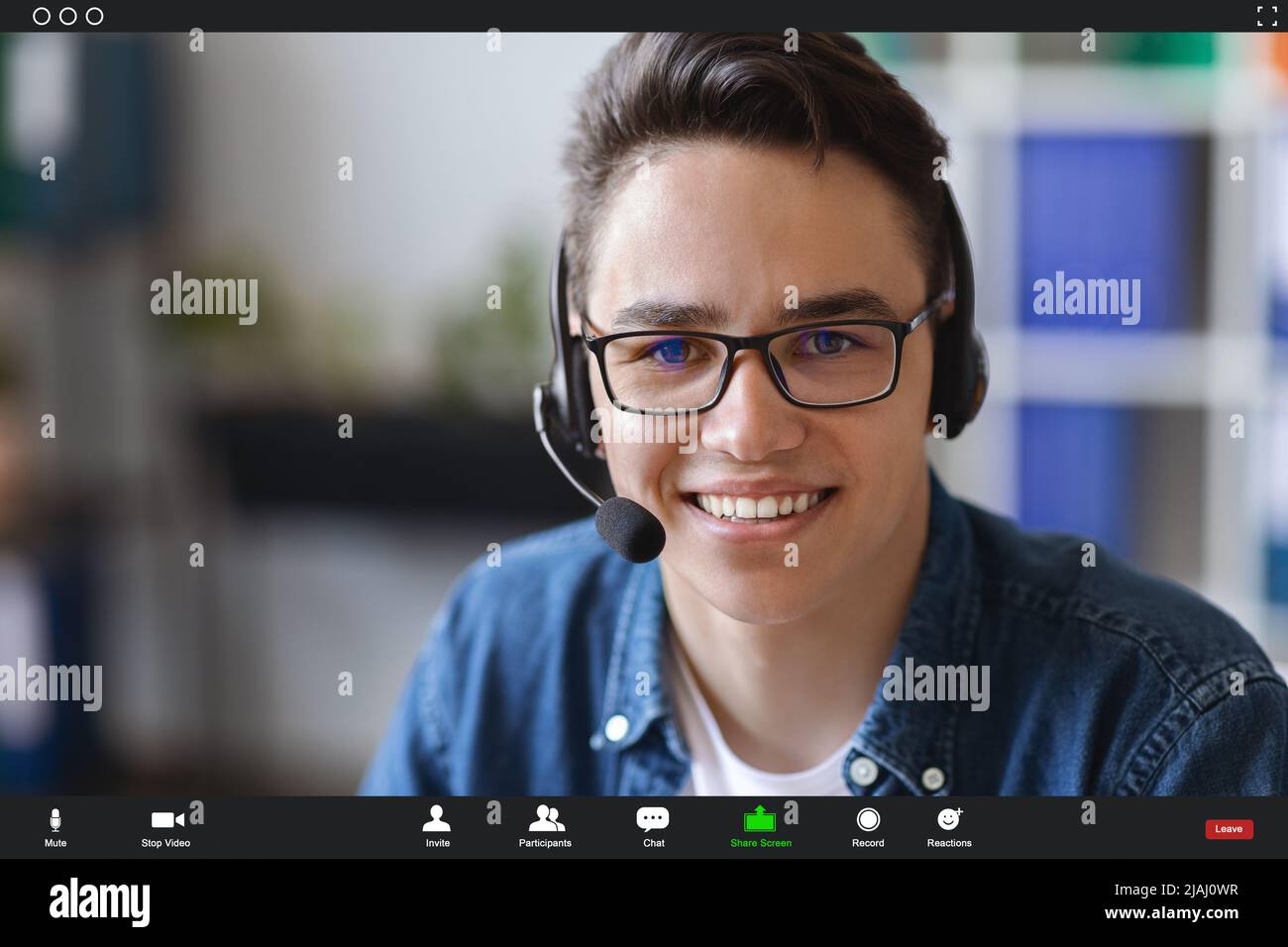 Teleconferenza. Scatto POV della videochiamata con l'uomo giovane sorridente che indossa la cuffia Foto Stock