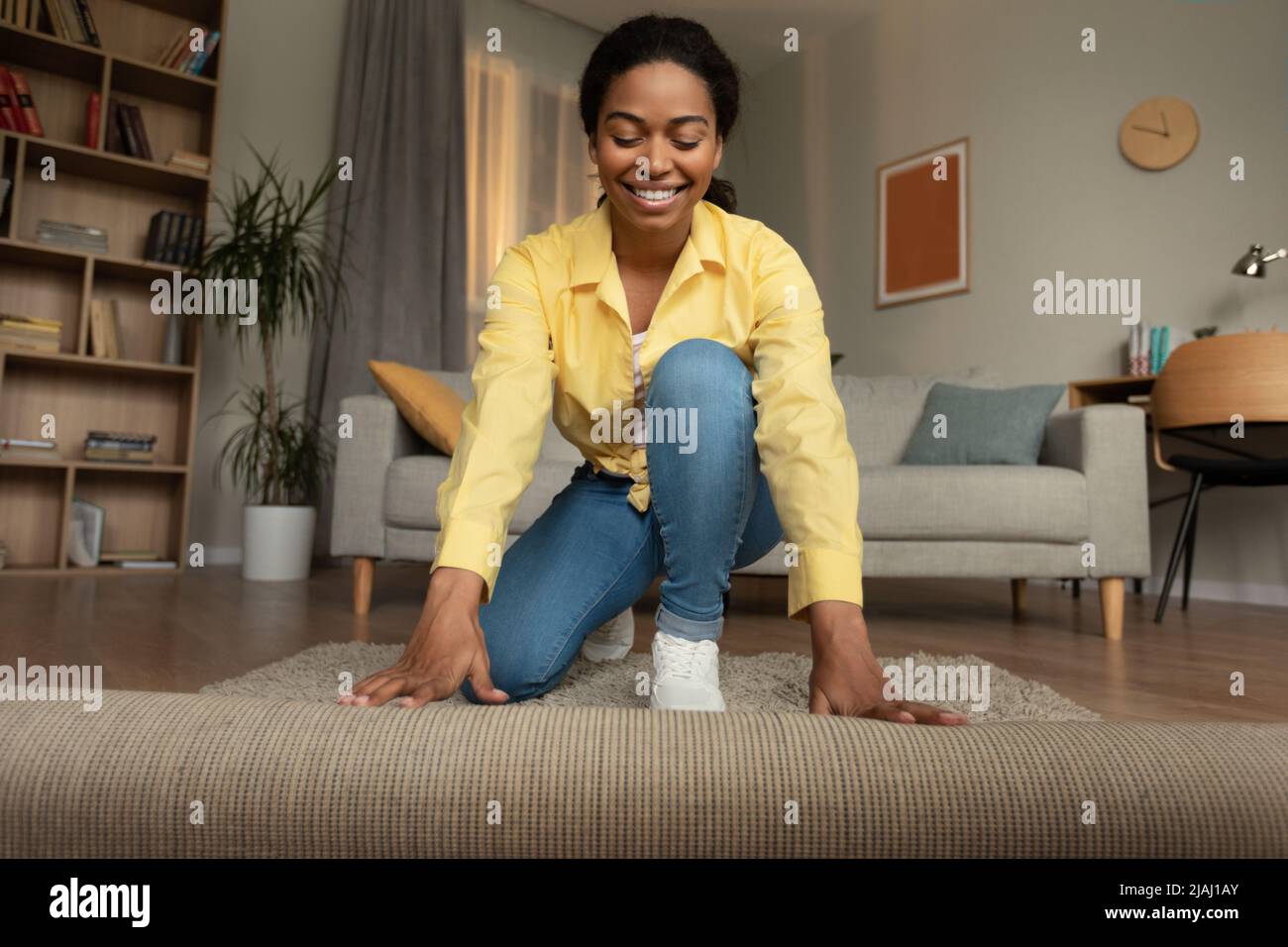 African Woman copertura pavimento con moquette decorazione stanza a casa Foto Stock