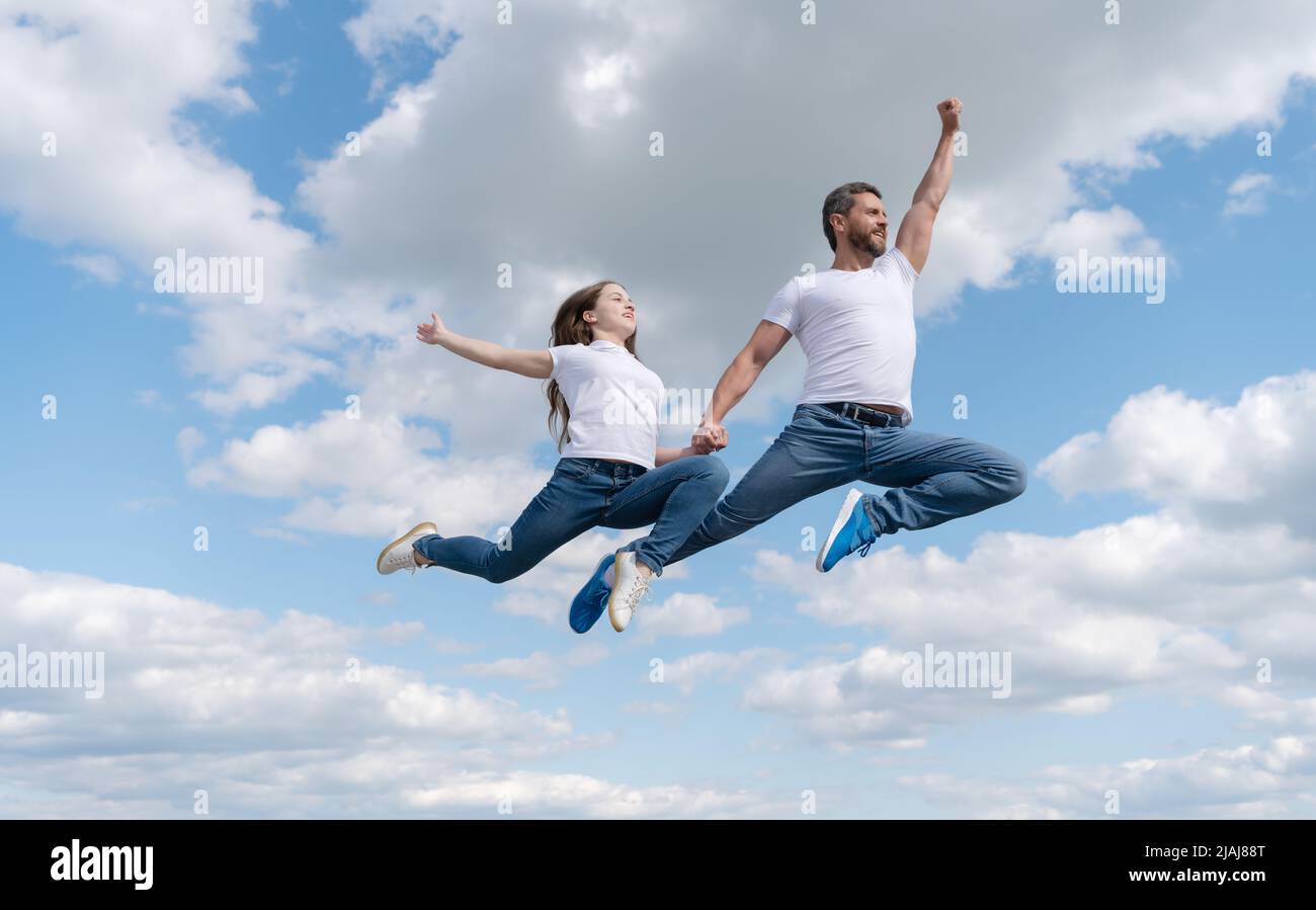 felice padre e figlia saltano in cielo. giorno di famiglia Foto Stock