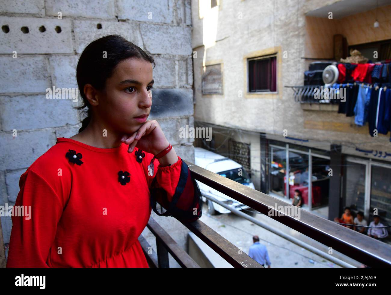 Jaramana, Siria. 30th maggio 2022. Hiba Moussa sorge sul balcone della sua casa a Jaramana, una città a tre chilometri a sud-est di Damasco, Siria, il 25 maggio 2022. Credit: Ammar Safarjalani/Xinhua/Alamy Live News Foto Stock