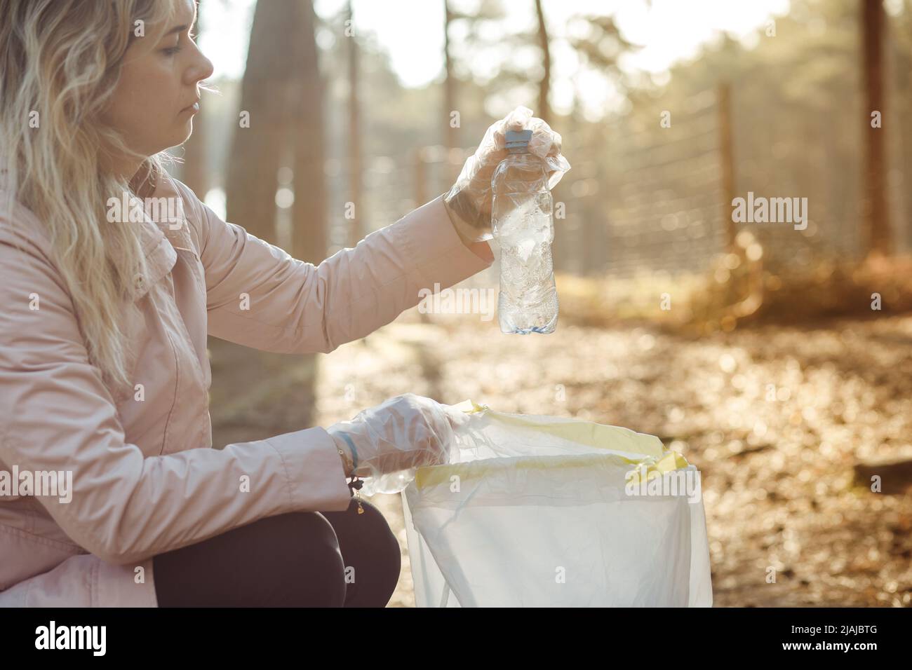 Donna triste volontario e assistente pulire la foresta da plastica bottiglia di scarto, rifiuti. Riciclaggio, inquinamento, eco-sostenibile Foto Stock