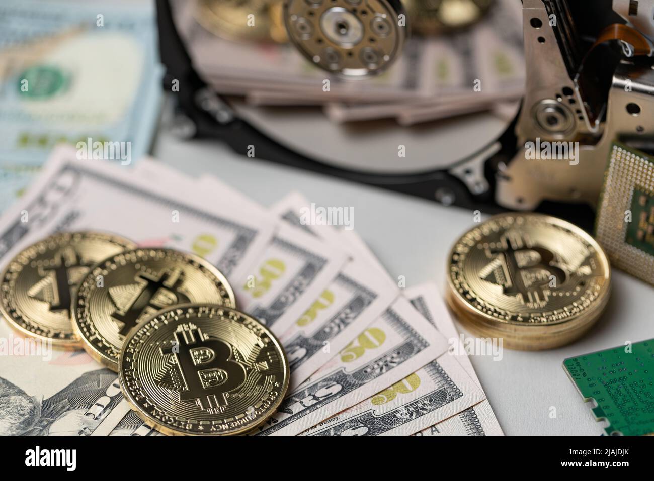 Banconote in dollari e bitcoin che si riflettono sul disco rigido. Concetto di stoccaggio della catena a blocchi e dell'estrazione criogenica. Foto Stock