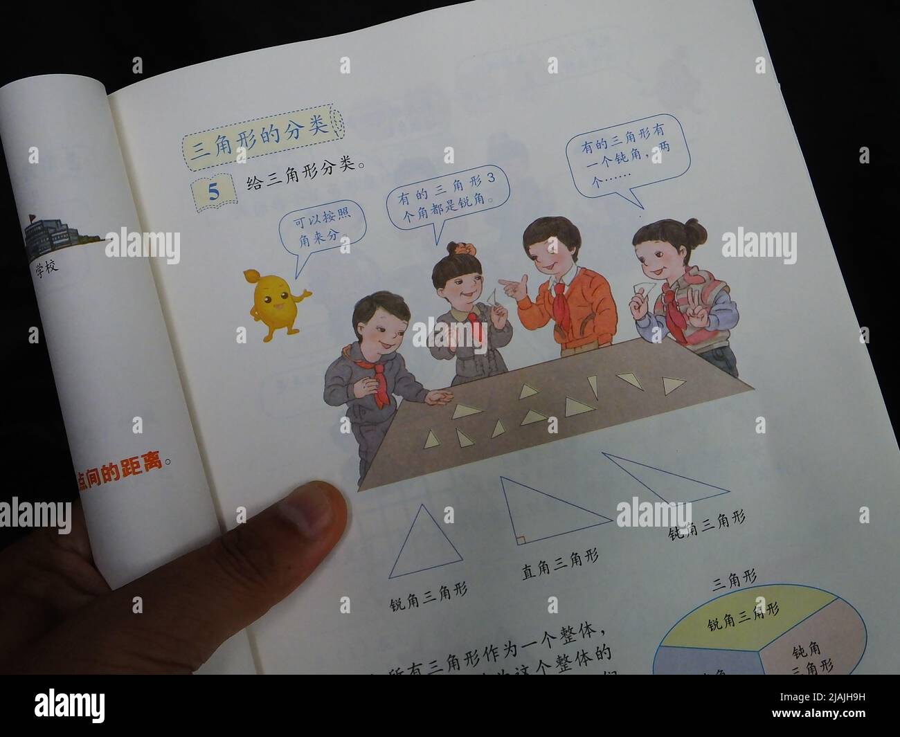 YICHANG, CINA - 31 MAGGIO 2022 - Un cittadino mostra le illustrazioni del secondo volume del libro di matematica di quarto grado per le scuole primarie pubblicato Foto Stock