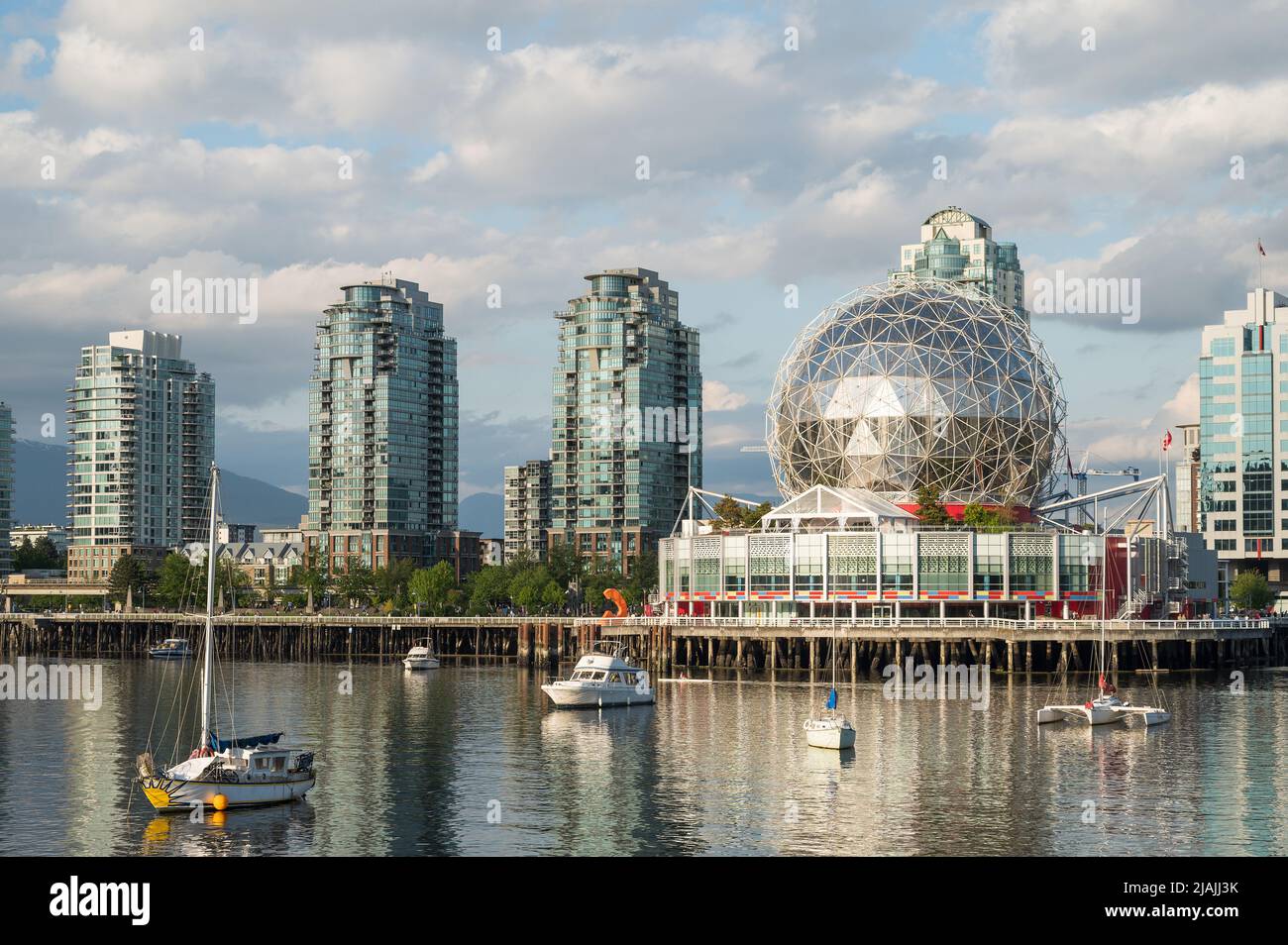 Vancouver Science World alla fine di False Creek con yacht ormeggiati nel porto. Foto Stock