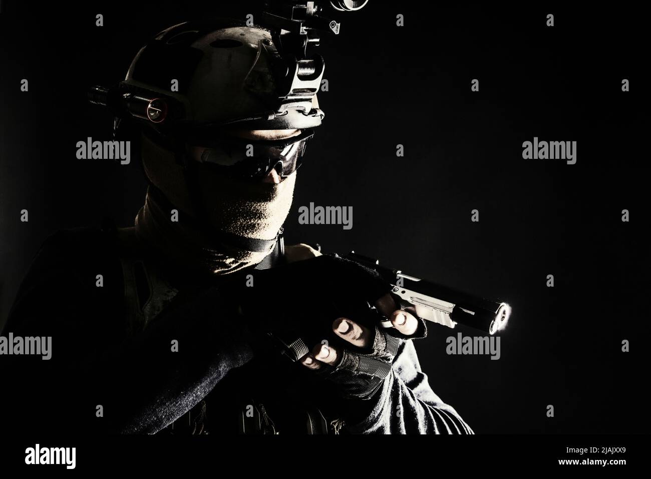 Polizia SWAT team fighter puntamento pistola mentre si sneaking nel buio. Foto Stock