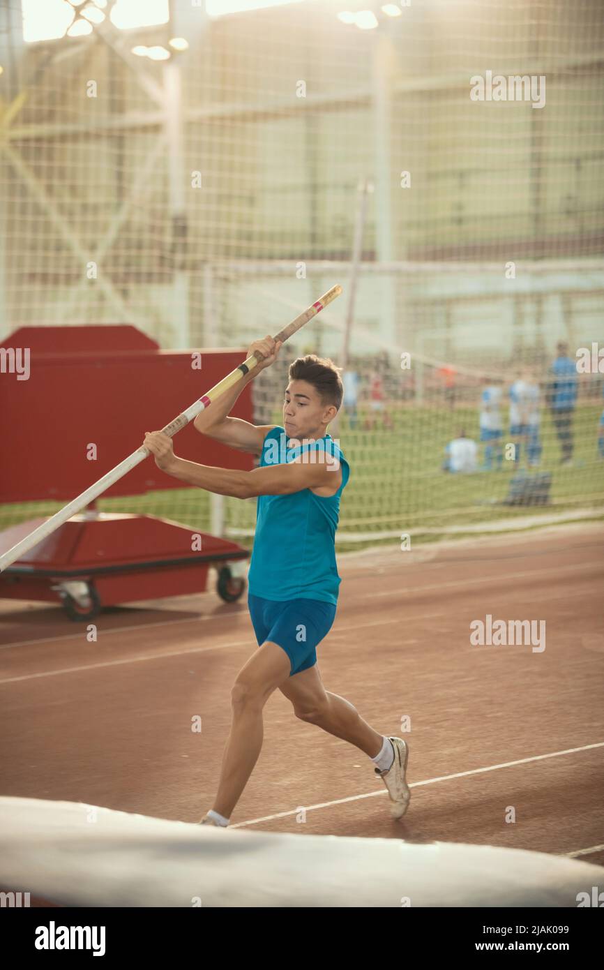 Pole vaulting training - giovane uomo in forma che sta per saltare Foto Stock