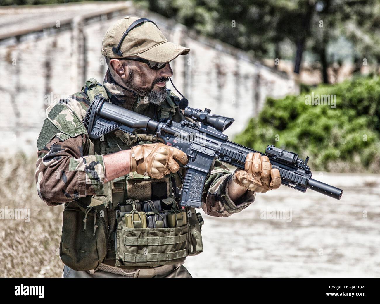 Mercenario privato della compagnia militare in uniforme da battaglia, tenendo in mano il fucile di servizio, pronto a combattere. Foto Stock